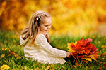 Kind in Herbstlaub